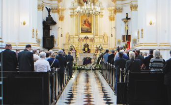 Son Arrives at Dad’s Funeral in Bright Suit Smiling, Priest Stops the Ceremony – Story of the Day